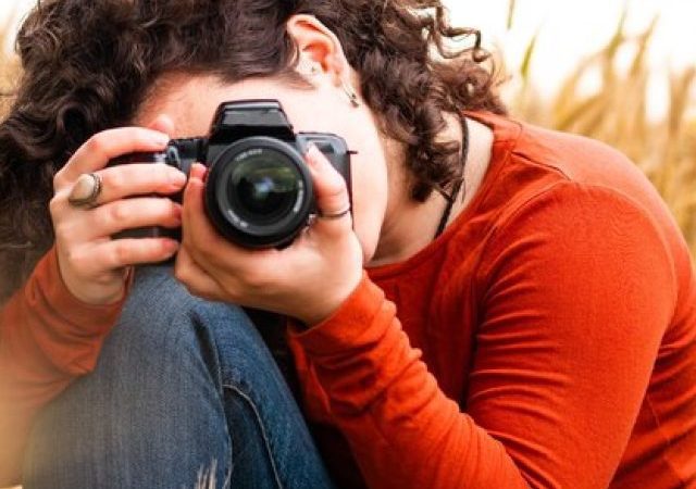 shallow-focus-shot-beautiful-young-female-taking-photo-with-her-camera_181624-42689